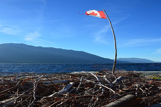 Gebeutelte Kanada Flagge in der Nähe eines wilden Camps am Ufer